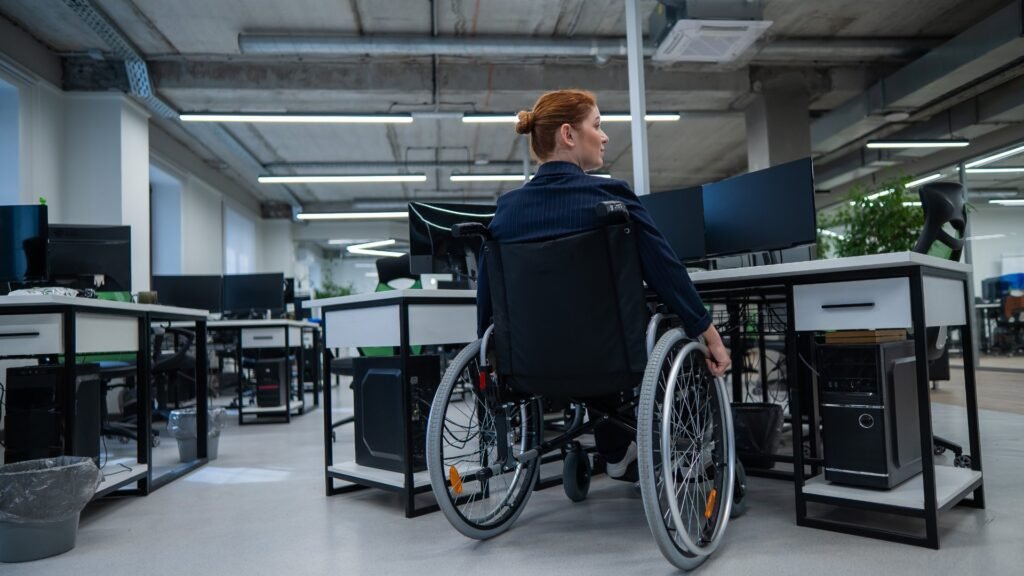 a wheechair bound woman working in office on her computer
