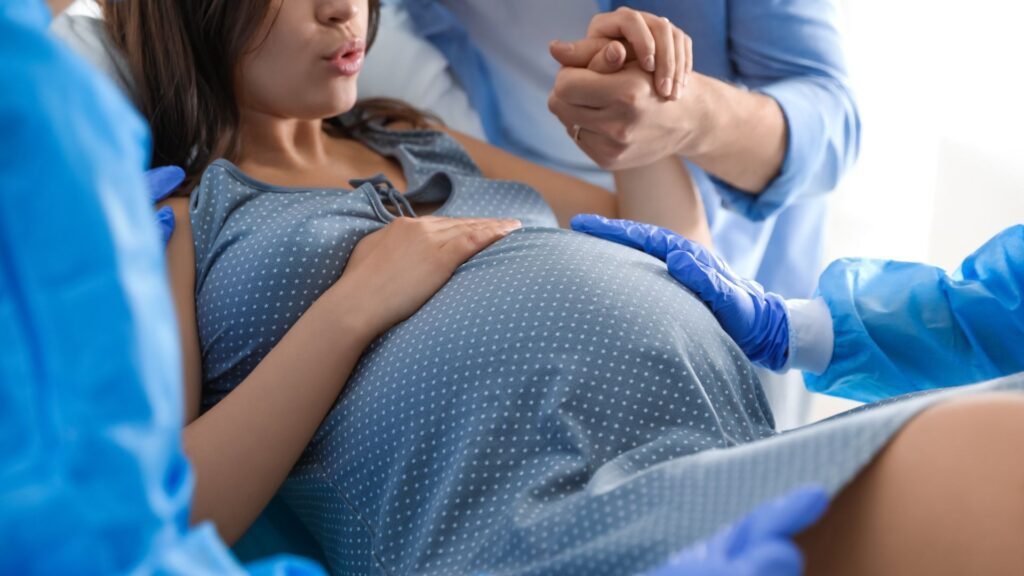 healthcare provider holding a pregnant woman's hand to help her deliver